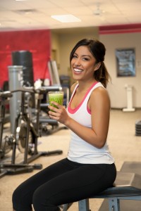 Girl in gym with a green smoothie