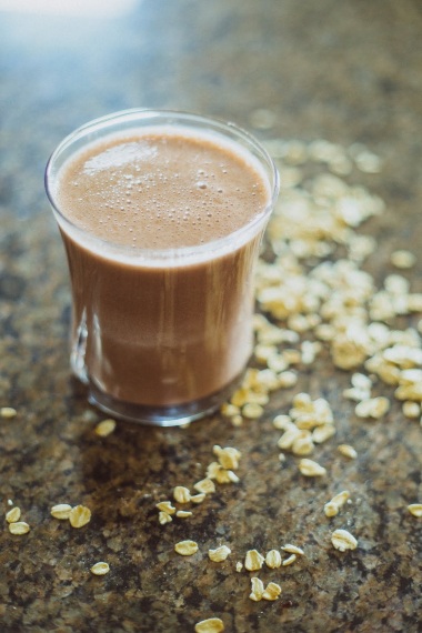 Glass with chocolate oatmeal protein energy smoothie ready for pre-workout.