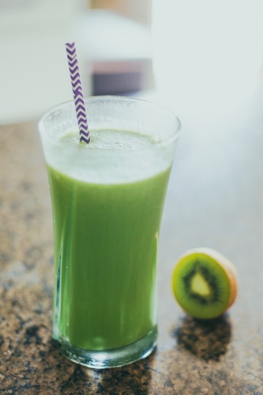 Green kiwi and kale energy smoothie on kitchen countertop